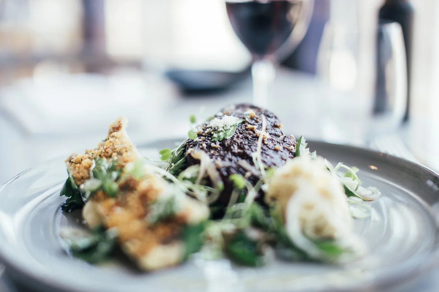 Gourmet plate with a glass of red wine in the background, served during a dinner at home in Montreal