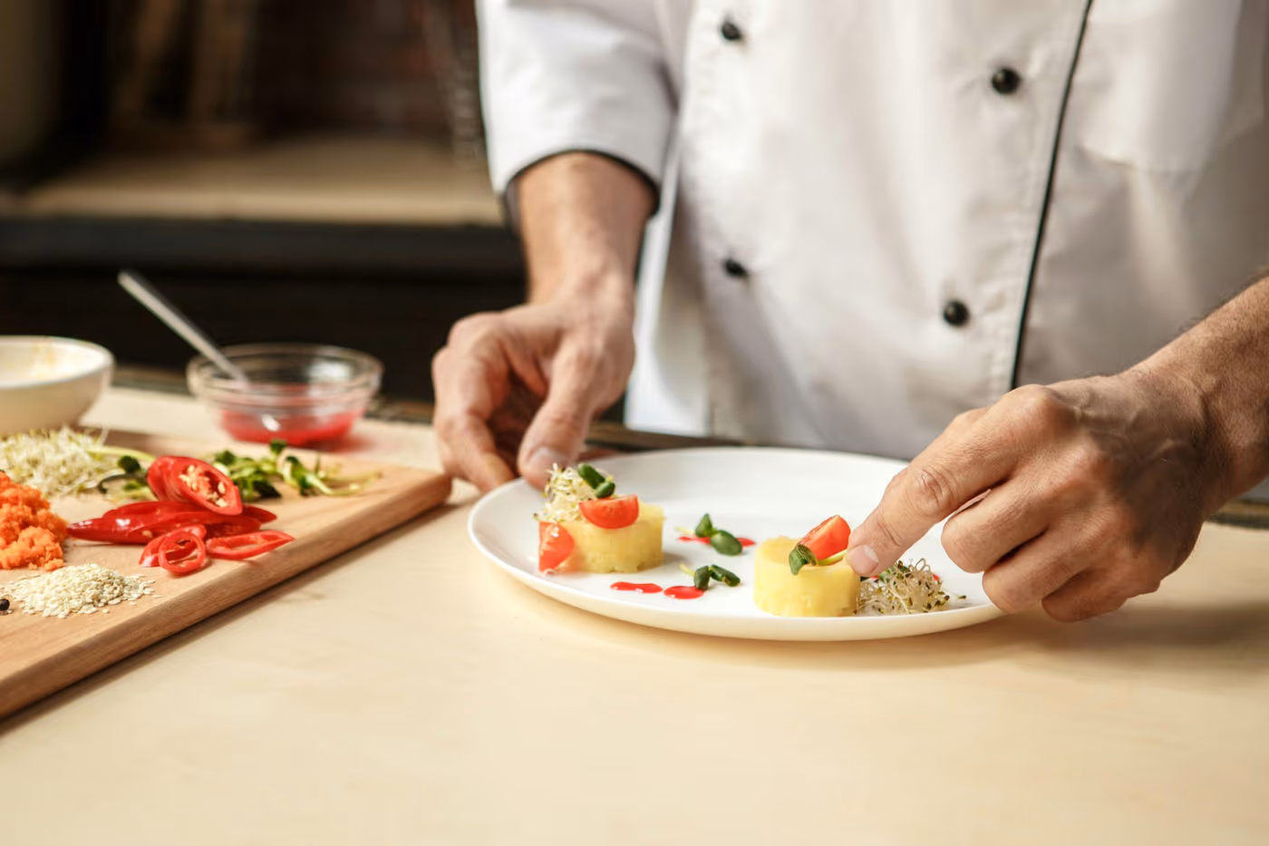 Chef privé qui dresse une assiette lors d'un repas gastronomique à domicile à Montréal, menu 5 services