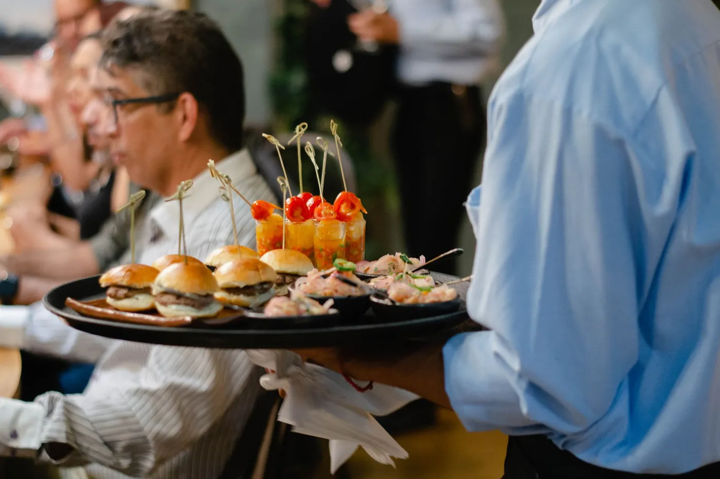 Serveur distribuant des bouchées lors d'un repas festif servi lors d'une soirée corporative de fin d'année à Montréal
