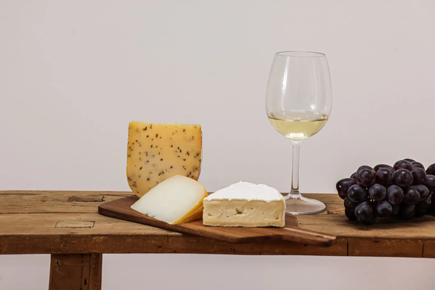 Artisan cheese board, grapes and a glass of Quebec white wine for a successful food and wine pairing at home