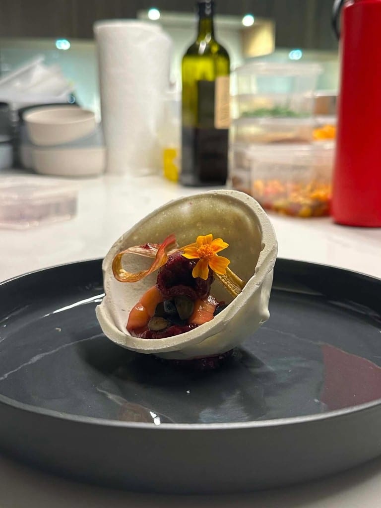 Canapé plated in a ceramic shell, garnished with a flower