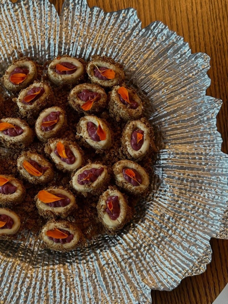 Round bites with a mauve filling presented on a silver platter