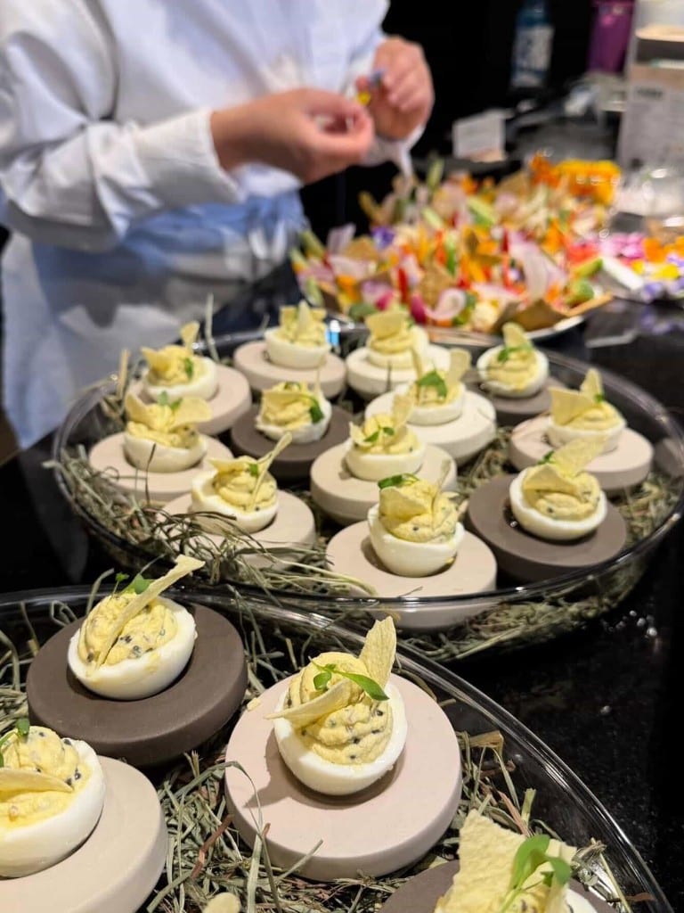 Mimosa eggs plated by Chef Max Delmont, visible in the background