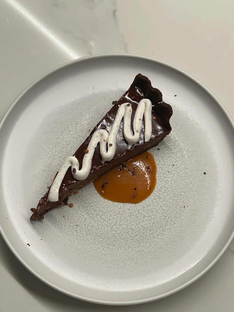 Chocolate tart with cream and caramel plated for service