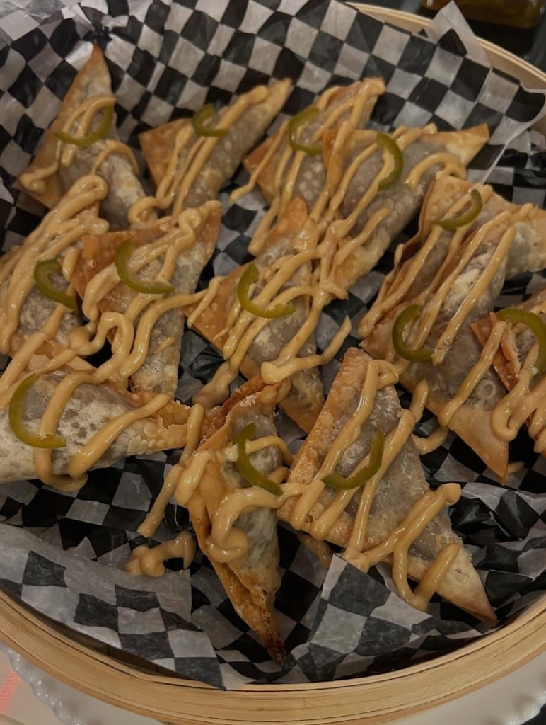 Wontons served with sauce and chili peppers